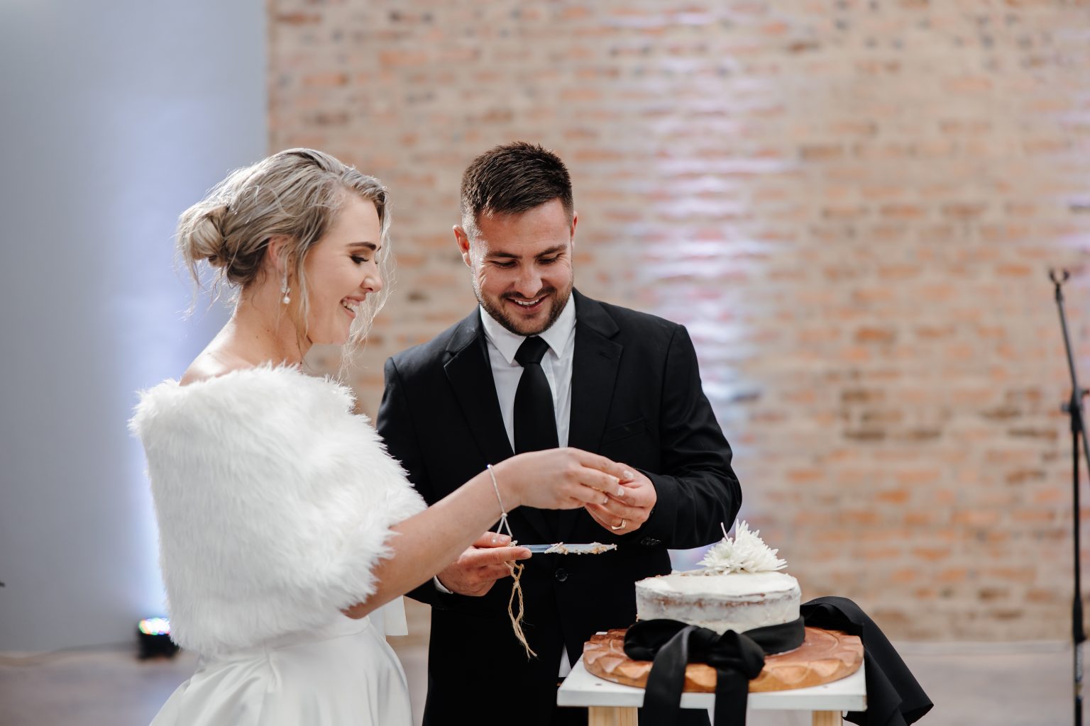 Couple holding Pretzel's graduation certificate in kitchen